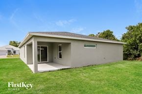 Port St. Lucie house for rent - a small gray house with a lawn and a grass yard