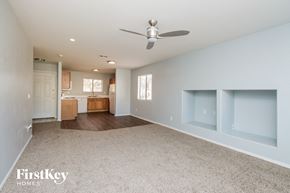 San Tan Valley house for rent - a empty living room with a ceiling fan and a kitchen