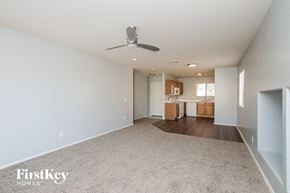 San Tan Valley house for rent - an empty living room with a ceiling fan and a kitchen