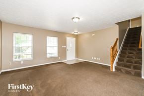 Indianapolis house for rent - A spacious room with a staircase leading to the upper floor.
