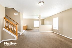 Indianapolis house for rent - A spacious room with a staircase and a window.