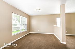 Indianapolis house for rent - A room with a carpeted floor and a window overlooking a fence.