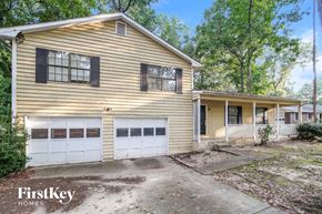Lawrenceville house for rent - a yellow house with a white garage door