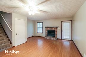 Lawrenceville house for rent - an empty living room with a fireplace and wooden floors