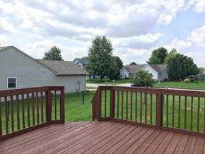 Indianapolis house for rent - A wooden deck with a railing overlooking a grassy area and houses.