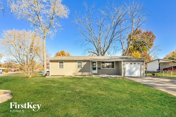 Florissant house for rent - a yellow house with a yard and a garage