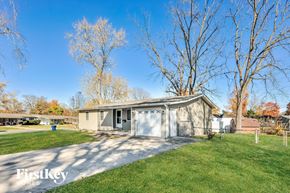 Florissant house for rent - a small gray house with a driveway and a garage door