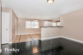 Florissant house for rent - the living room and kitchen of a home with black vinyl flooring