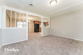 Conyers house for rent - A spacious room with a carpeted floor and a refrigerator in the corner.