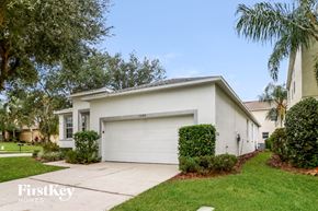 Lakeland house for rent - A white house with a garage is surrounded by greenery.