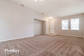 Lakeland house for rent - A spacious room with a carpeted floor and a chandelier hanging from the ceiling.