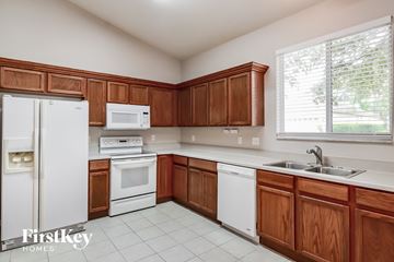 Lakeland house for rent - A kitchen with wooden cabinets and white appliances.