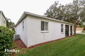 Lakeland house for rent - A small white house with a red brick border around the grass.