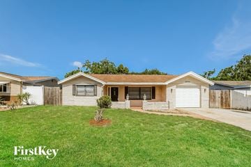 Port Richey house for rent - a small white house with a yard and a driveway