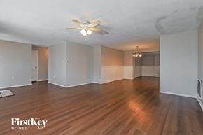 Port Richey house for rent - an empty living room with wood floors and a ceiling fan