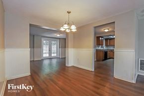 Port Richey house for rent - an empty living room and kitchen with wood floors and a chandelier