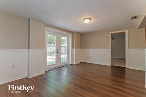 Port Richey house for rent - an empty living room with wood floors and a door to a patio