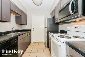 Sugar Land house for rent - A kitchen with a white door and a black counter top.
