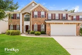 Charlotte house for rent - a brick house with a white garage door and a lawn