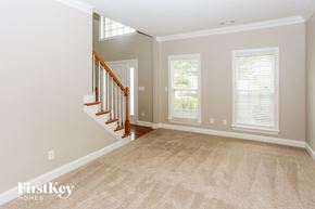 Charlotte house for rent - a living room with a staircase and a carpeted floor
