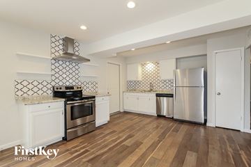 Glendale house for rent - a kitchen with white cabinets and stainless steel appliances