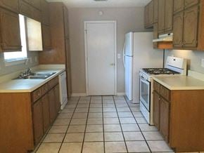 Hampton house for rent - an empty kitchen with a refrigerator and a sink