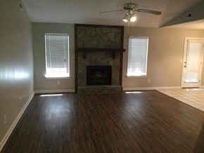 Hampton house for rent - an empty living room with a fireplace and wooden floors