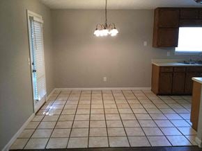 Hampton house for rent - an empty kitchen and dining room with tile flooring