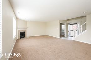 Fishers house for rent - an empty living room with a fireplace and a staircase