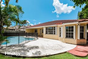 Miami house for rent - a backyard with a pool and a house with a fence