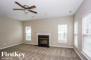 Charlotte house for rent - a living room with a fireplace and a ceiling fan