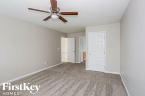 Charlotte house for rent - a bedroom with a ceiling fan and a carpeted floor