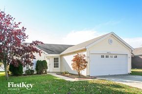 Indianapolis house for rent - a white house with a white garage door and a lawn