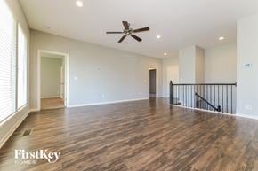 Peculiar house for rent - A spacious room with wooden flooring and a ceiling fan.