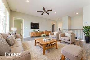 Peculiar house for rent - A living room with a beige couch, a wooden coffee table, and a flat-screen TV mounted on the wall.