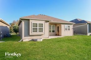 Peculiar house for rent - A house with a brown roof and a white door is surrounded by a grassy lawn.