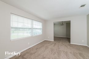 Jacksonville house for rent - a spacious living room with carpet and a large window