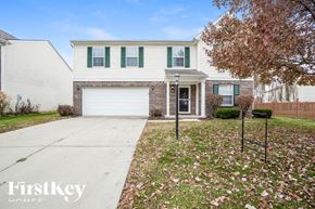 Noblesville house for rent - A house with a white garage door and green shutters.