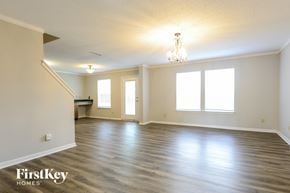 Camby house for rent - A spacious room with wooden floors and a chandelier.