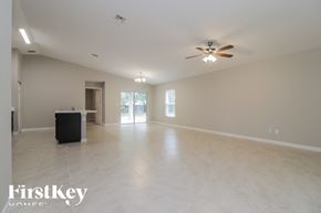 Palm Bay house for rent - A spacious room with a ceiling fan and a black box on the floor.