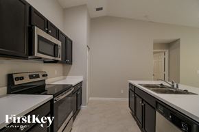 Palm Bay house for rent - A kitchen with black cabinets and a white countertop.