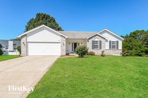 Saint Charles house for rent - A white house with a garage is surrounded by a green lawn.
