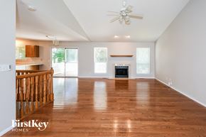Saint Charles house for rent - A spacious living room with wooden floors and a ceiling fan.