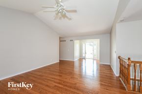 Saint Charles house for rent - A spacious room with wooden floors and a ceiling fan.