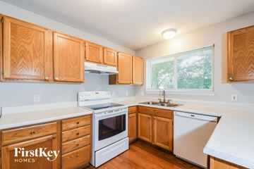 Saint Charles house for rent - A kitchen with wooden cabinets and a white dishwasher.