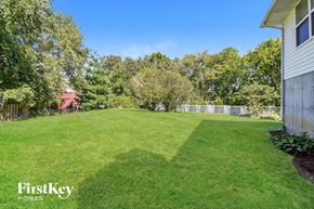Saint Charles house for rent - A lush green lawn with trees and a house in the background.