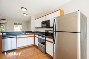 Orlando house for rent - a kitchen with white cabinets and a stainless steel refrigerator