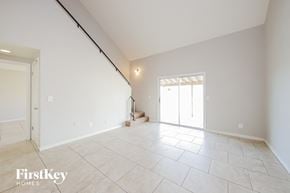 Peoria house for rent - A spacious room with a tile floor and a window with blinds.