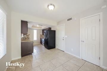 Peoria house for rent - A kitchen area with a black fridge and a white door.