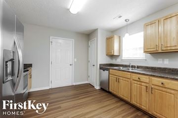 Wingate house for rent - a kitchen with wood flooring and wooden cabinets and stainless steel appliances